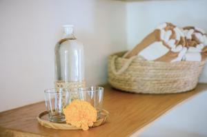 a table with two glasses and a bottle and a basket at Mule Malu Tropical Stay in Uluwatu