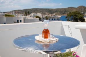 a bottle of honey and two glasses on a table at Pension Barbara in Katapola