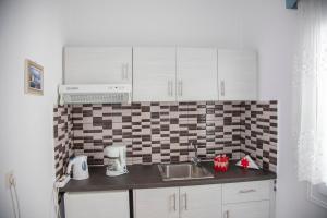 a small kitchen with white cabinets and a sink at Pension Barbara in Katapola