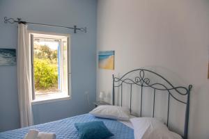 a bedroom with a bed and a window at Pension Barbara in Katapola