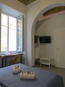 a bedroom with a bed with two pairs of shoes on it at L'arco e il vico in Naples