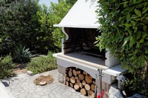 a outdoor fireplace with a pile of fire wood at Villa Kovach in Krk