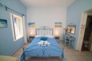a blue bedroom with a bed and a bathroom at Pension Barbara in Katapola