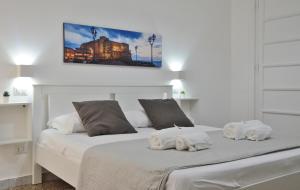 ナポリにあるMellos B&Bの白いベッドルーム(ベッドに白いタオル2枚付)