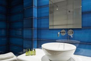 a bathroom with a sink and a blue tiled wall at Cozy and Bright 2BD Apartment in Kolonaki in Athens