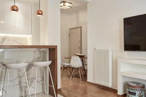 a kitchen with a counter and stools in a room at Cozy and Bright 2BD Apartment in Kolonaki in Athens