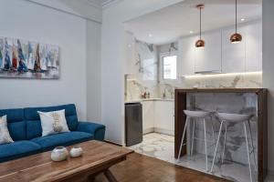 a living room with a blue couch and a table at Cozy and Bright 2BD Apartment in Kolonaki in Athens
