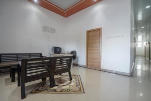 a room with two benches and a table and a door at OYO 945 Mega Kost 2 in Palembang