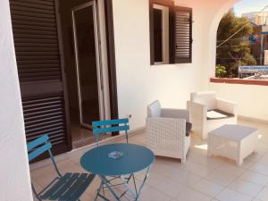 a patio with chairs and a blue table and chairs at Villa Iavernaro in Pulsano
