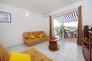 a living room with a couch and a table at Apartmani Mia Šolta in Nečujam