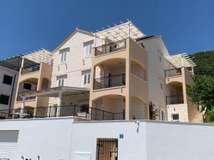 un edificio de apartamentos con balcones y una pared blanca en Villa Marina Bol, en Bol