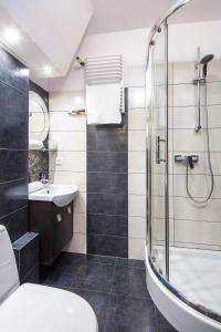 a bathroom with a shower and a toilet and a sink at Sleepy3city Władysława IV 50 in Gdynia