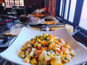 a table with a plate of food on a table at Pousada Villa das Pedras in Pirenópolis