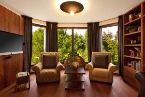 a living room with two chairs and a tv at Wellness & Spa Boutique Hotel Villa Memories in Fryšták