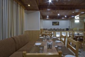 una sala da pranzo con un lungo tavolo e sedie di Hotel Hayer Regency a Manāli