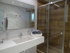 a bathroom with a sink and a shower at Selana Suites in Chrisopigi