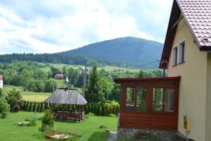a house with a view of a field and a mountain at Słoneczne Chaty pod Sonami Kasina Wielka in Kasina Wielka