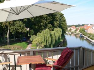 une table et des chaises avec un parasol sur un balcon dans l'établissement Venedig und Amsterdam, à Plau am See