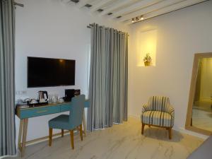 a room with a desk and a tv and a chair at Selana Suites in Chrisopigi