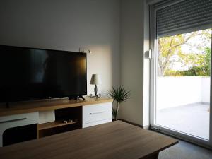 a living room with a flat screen tv and a window at Holiday Home Višnja in Nin