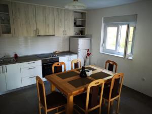 a kitchen with a wooden table and chairs and a kitchen with white cabinets at Holiday Home Višnja in Nin