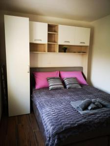 a bedroom with a large bed with pink pillows at Holiday Home Višnja in Nin