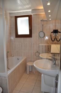 a bathroom with a tub and a sink and a bath tub at Les Weitchiis in Veyrier-du-Lac