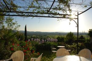 a table and chairs in a garden with flowers at Mas des Tours Chambre d'hôtes in Tornac +8 photos