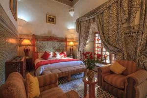 una camera da letto con un letto, un divano e delle sedie di Palais Dar Donab a Marrakech