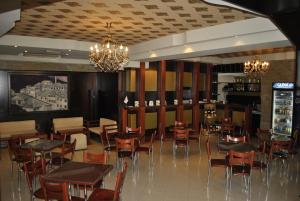 a restaurant with tables and chairs and a bar at Hotel Bleta in Gjirokastër