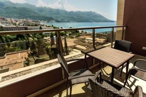a table and chairs on a balcony with a view at Apartments Harmonia Colours in Budva