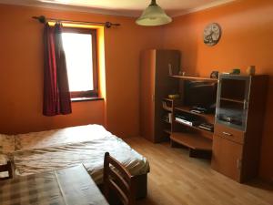 1 dormitorio con cama, mesa y ventana en Borostyánkert Étterem & Vendégház en Sitke