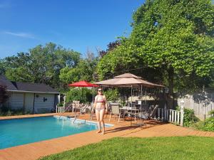 a woman in a bikini standing next to a swimming pool at Harrington House Picton in Picton