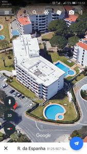 ヴィラモウラにあるFerias Vilamoura T1 Grande com piscinaの白い大きな建物で、目の前にプールがあります。