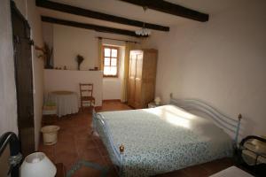 Schlafzimmer mit einem Bett, einem Tisch und einem Fenster in der Unterkunft Mas des Tours Chambre d'hôtes in Tornac