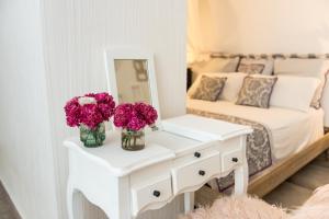 una camera da letto con un letto e un tavolo bianco con fiori di ROOM2 a Frascati