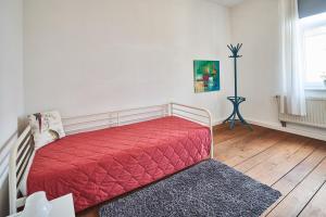 フリードリヒスハーフェンにあるCasa Pinosのベッドルーム1室(赤い掛け布団付きのベッド1台付)