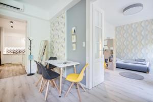 een woonkamer met een tafel en stoelen bij BpR Color Fusion Home with A/C in Boedapest