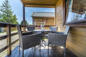 a patio with chairs and a table on a deck at Draga in Jastarnia