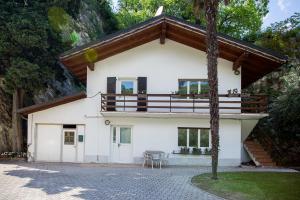 a white house with a balcony and a table at Apartments Suster in Nago-Torbole