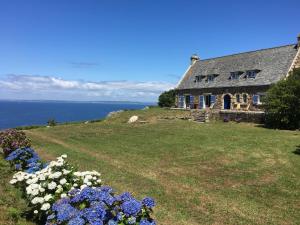 a house on a hill with flowers in front of it at Kerloulou in Poullan-sur-Mer