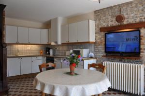 a kitchen with a table with a vase of flowers on it at Les Weitchiis in Veyrier-du-Lac