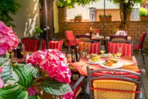 una mesa con platos de comida y flores rosas en Goldener Pfropfenzieher, en Oberwesel