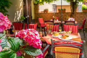 a table with plates of food and pink flowers at Goldener Pfropfenzieher in Oberwesel