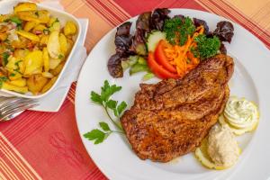 un plato de comida con carne y verduras y una ensalada en Goldener Pfropfenzieher, en Oberwesel