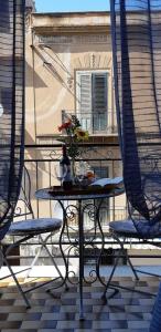 a table and chairs on a balcony with a window at Domus Mea in Trabia