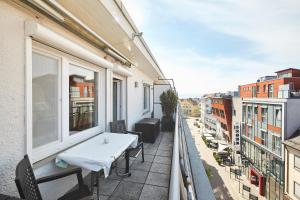 een balkon met een tafel en stoelen in een gebouw bij Casa Pinos City in Friedrichshafen