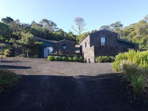 una casa de piedra con una entrada delante de ella en O Farrobo en Madalena