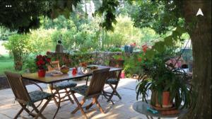 un patio con mesa y sillas en un jardín en MAS DE LA RESPELIDO, en Cabannes