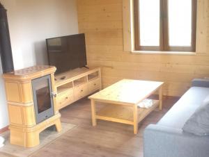 a living room with a tv and a coffee table at Słoneczne Chaty pod Sonami Kasina Wielka in Kasina Wielka